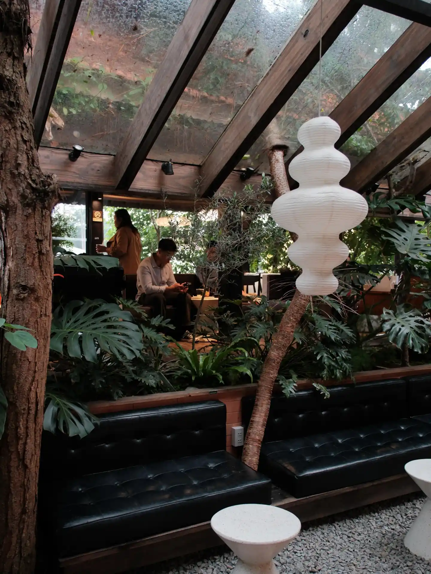 Góc ngồi dưới mái gỗ và cây xanh tại Cafe Đợi Một Người Yersin