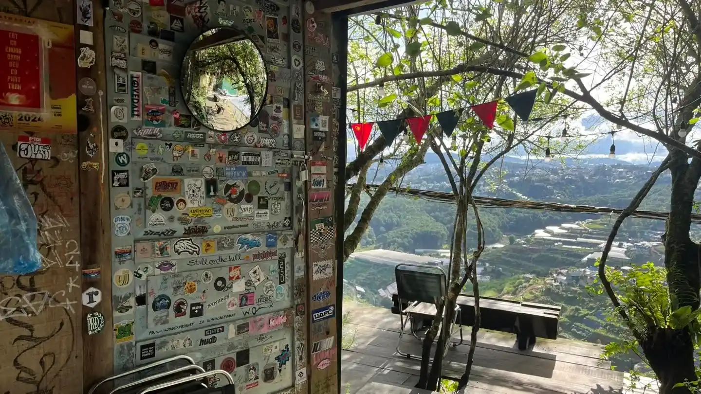 Góc trong nhà phủ sticker và khung nhìn ra cây xanh ở Kong cafe Dalat